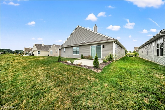 rear view of property featuring a patio area and a yard