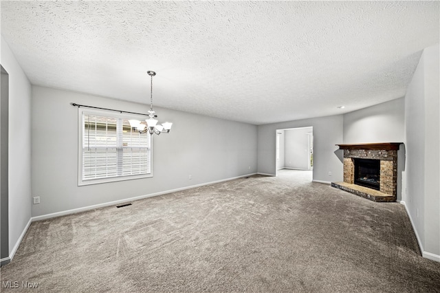 unfurnished living room with carpet flooring, a textured ceiling, and a stone fireplace