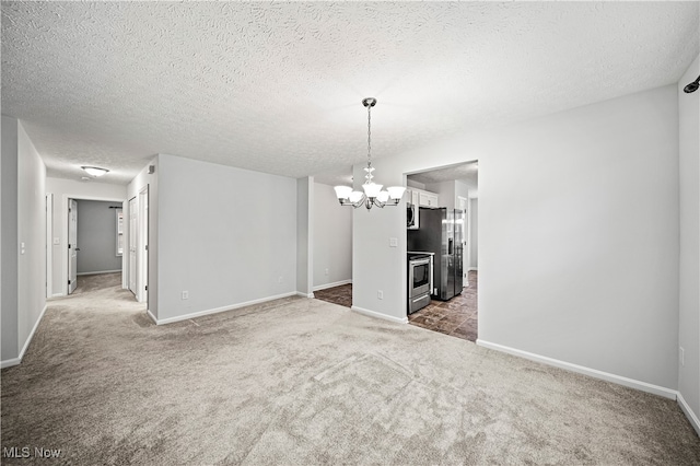 carpeted spare room featuring a textured ceiling and a chandelier