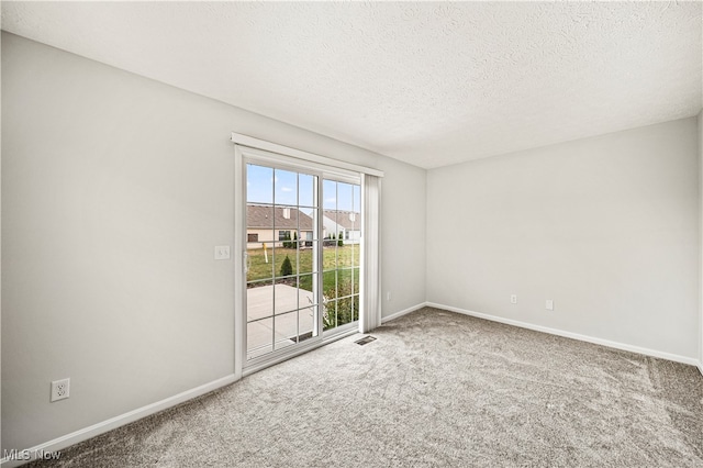 carpeted spare room with a textured ceiling