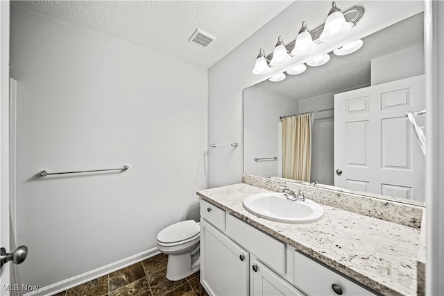 bathroom featuring vanity, a textured ceiling, toilet, and a shower with shower curtain