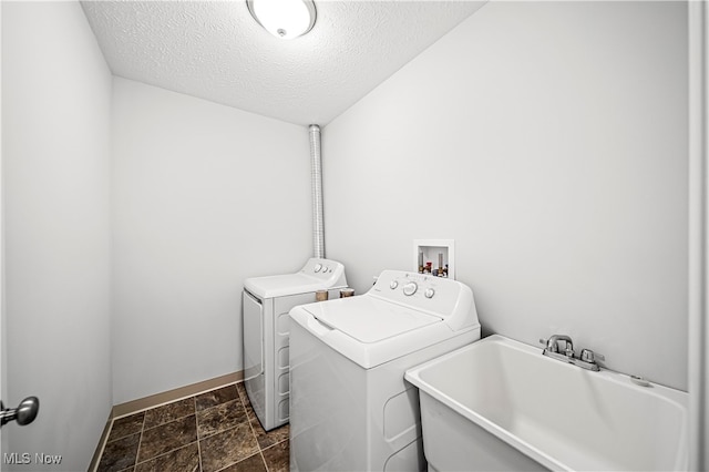 laundry area with separate washer and dryer, sink, and a textured ceiling