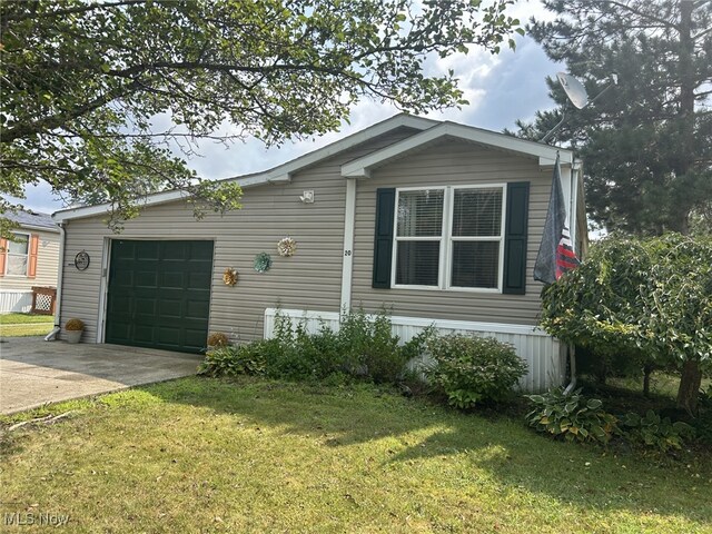 manufactured / mobile home with a garage and a front lawn