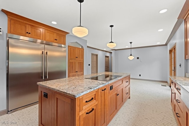 kitchen with light stone counters, black electric cooktop, built in refrigerator, a center island, and decorative light fixtures