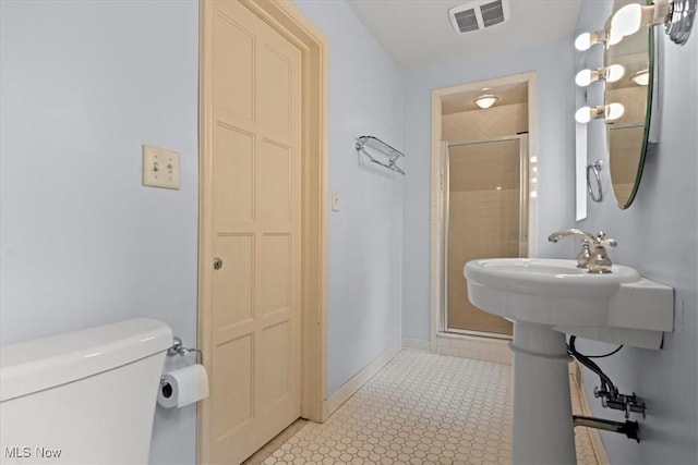 full bathroom with toilet, a stall shower, baseboards, and visible vents