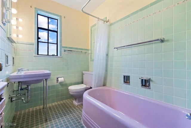 full bathroom featuring shower / bath combo with shower curtain, tile patterned flooring, toilet, and tile walls