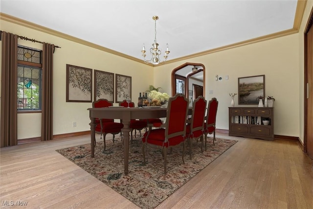 dining space featuring baseboards, crown molding, a chandelier, and wood finished floors