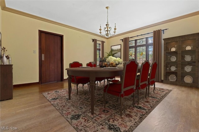 dining room with crown molding, baseboards, wood finished floors, and a notable chandelier