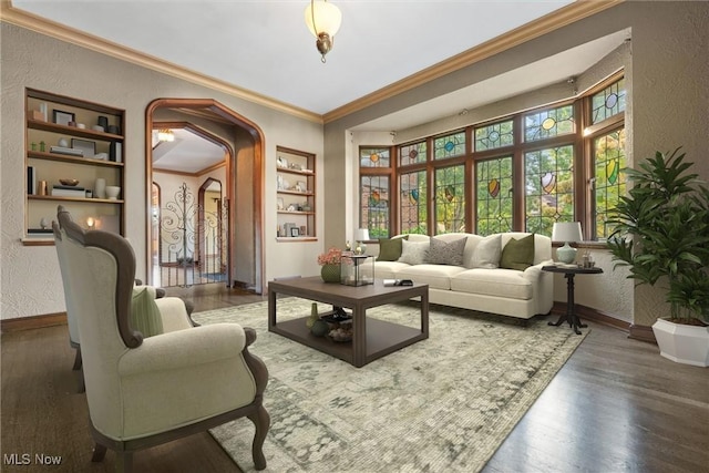 sitting room with arched walkways, a textured wall, baseboards, and wood finished floors