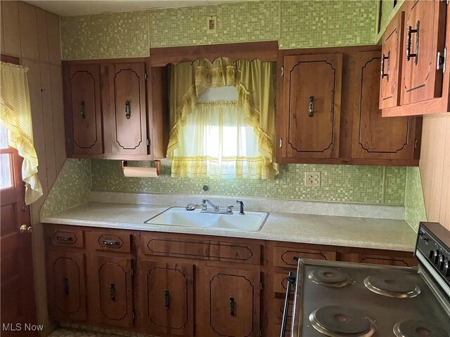 kitchen with backsplash, stainless steel range with electric cooktop, and sink