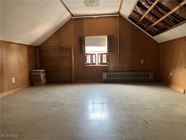 bonus room with lofted ceiling, wood walls, radiator, and tile patterned floors