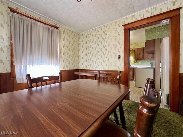 unfurnished dining area featuring wallpapered walls and wainscoting