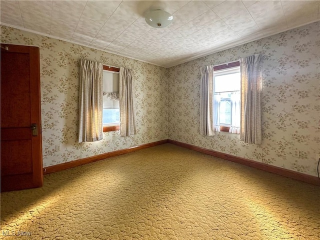 unfurnished room featuring light carpet, baseboards, and wallpapered walls