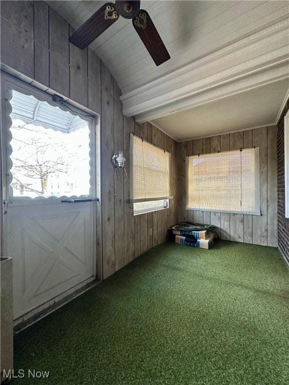 unfurnished sunroom featuring ceiling fan and beam ceiling