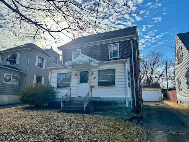 view of front of home featuring an outbuilding, brick siding, entry steps, a garage, and driveway