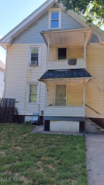 view of front of home with cooling unit and a front lawn