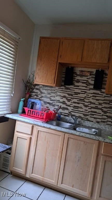 kitchen with light brown cabinetry, light tile patterned flooring, and decorative backsplash