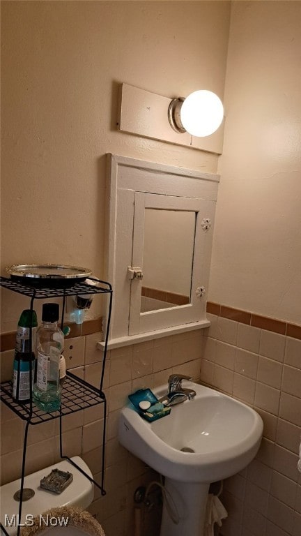 bathroom with decorative backsplash, tile walls, and toilet