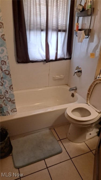 bathroom featuring shower / tub combo with curtain, toilet, and tile patterned floors