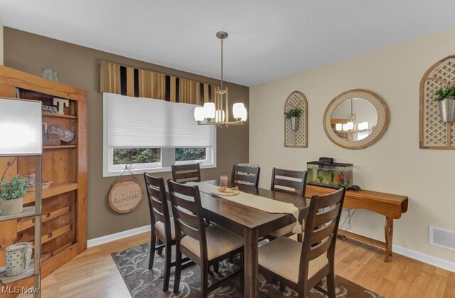 dining room with an inviting chandelier and light wood-type flooring