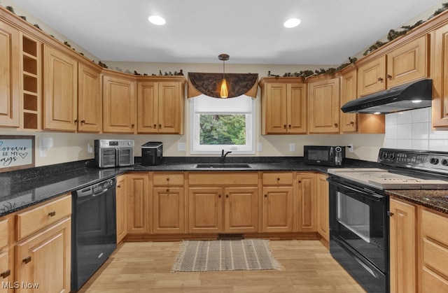 kitchen with dark stone counters, light hardwood / wood-style flooring, black appliances, sink, and backsplash