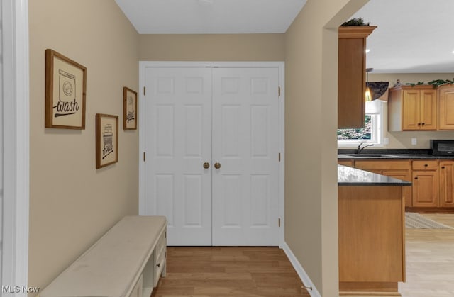 hallway featuring sink and light wood-type flooring