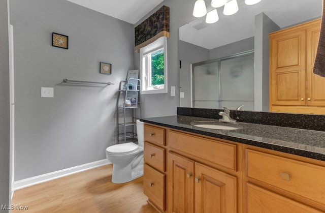 bathroom featuring vanity, toilet, and hardwood / wood-style flooring