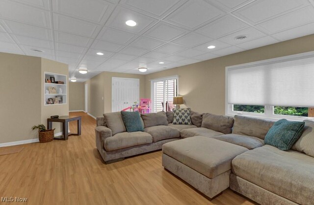 living room featuring built in features and light wood-type flooring