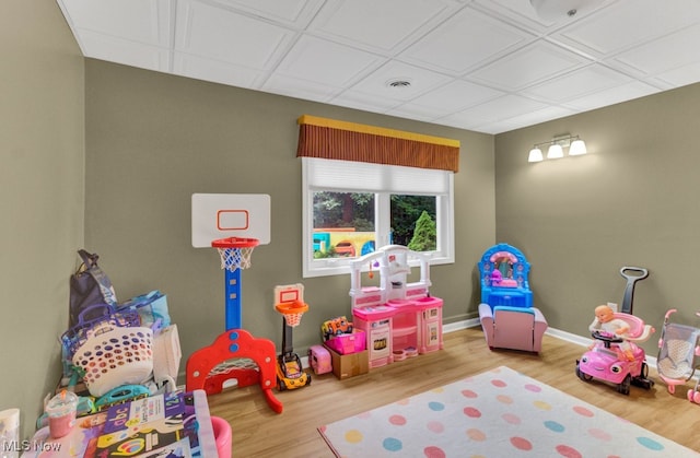 recreation room with a drop ceiling and light hardwood / wood-style floors