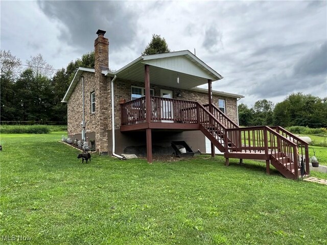 rear view of property with a deck and a yard