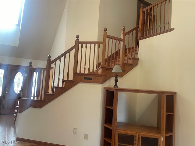 staircase with lofted ceiling and wood-type flooring