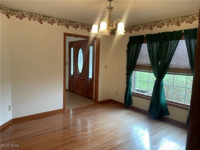 entrance foyer featuring light hardwood / wood-style flooring and a notable chandelier