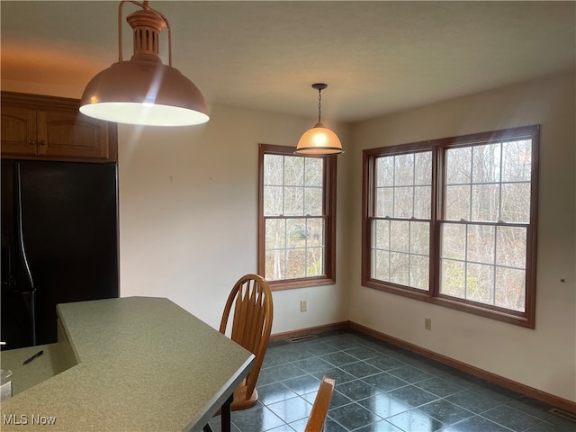 unfurnished dining area with dark tile patterned flooring