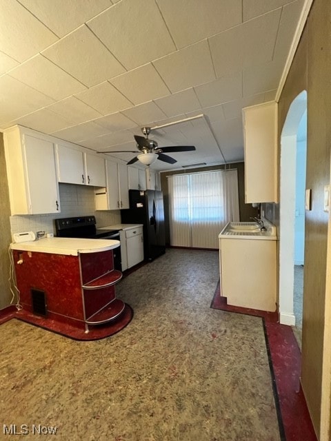 kitchen with black appliances, backsplash, white cabinetry, ceiling fan, and sink