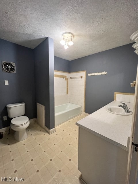 bathroom featuring a textured ceiling, vanity, and toilet