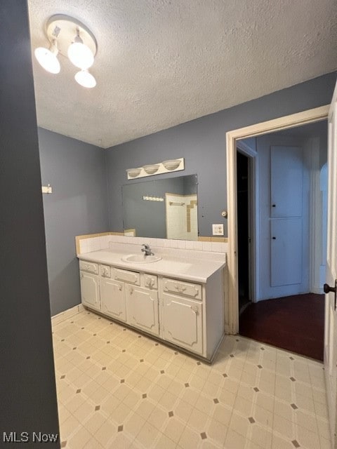 bathroom featuring tile patterned floors, vanity, and a textured ceiling