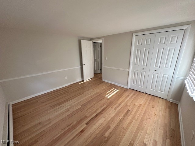 unfurnished bedroom featuring light hardwood / wood-style flooring and a closet