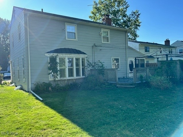 rear view of property featuring a lawn