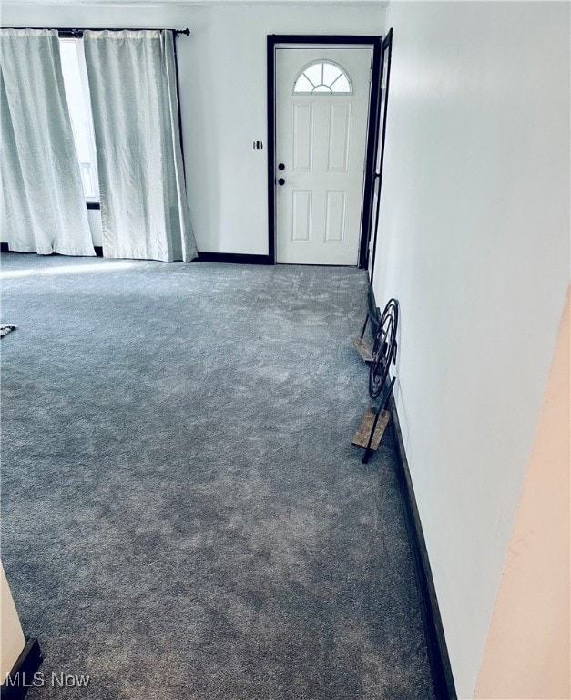 entrance foyer featuring dark colored carpet