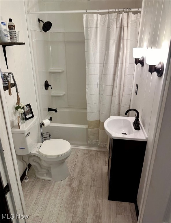 full bathroom with toilet, vanity, wood-type flooring, and shower / bathtub combination with curtain