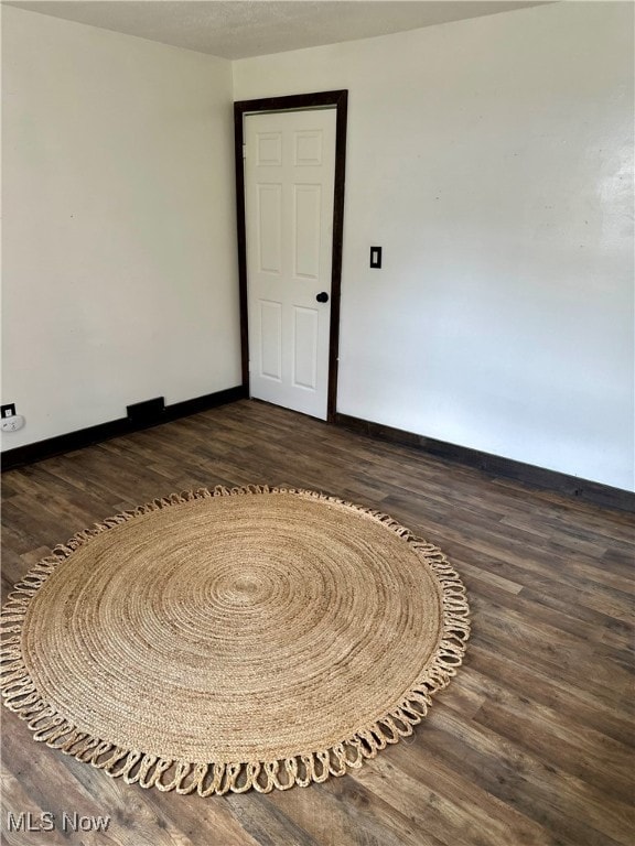 empty room with dark wood-type flooring