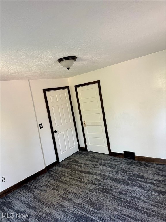 carpeted spare room with a textured ceiling