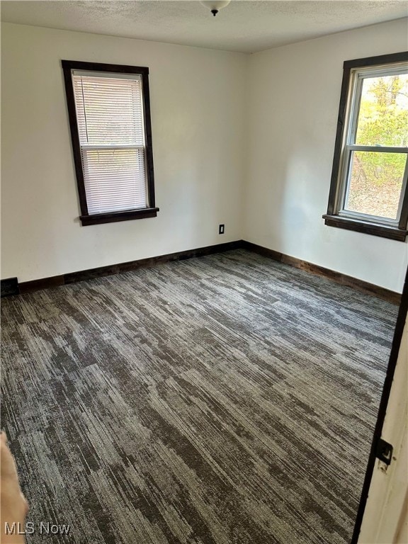 carpeted spare room with a textured ceiling