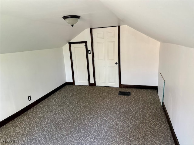 additional living space with lofted ceiling and dark carpet