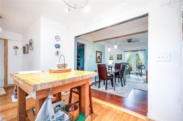 dining room featuring french doors, hardwood / wood-style flooring, and rail lighting