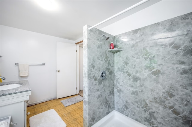 bathroom featuring tiled shower, tile patterned floors, and vanity