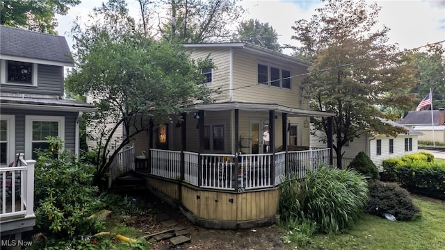 back of property featuring covered porch