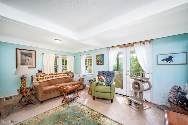 living room with carpet floors, french doors, and beamed ceiling