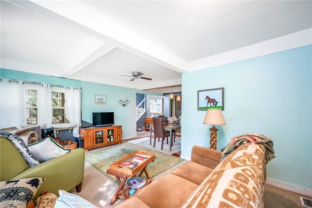 living room featuring beamed ceiling and ceiling fan