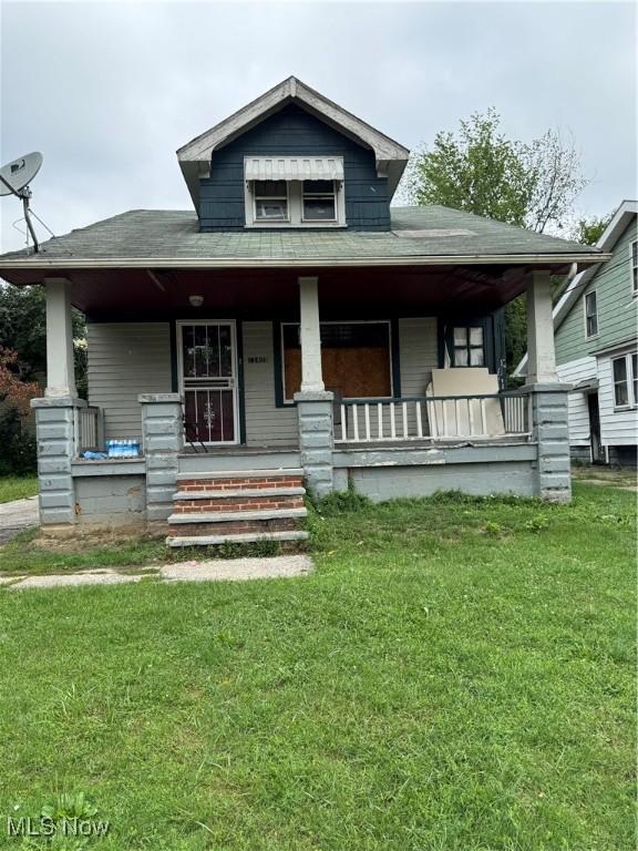 view of front of house featuring covered porch and a front lawn